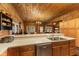 A charming kitchen is designed with wood-paneled walls, a breakfast bar, wood cabinetry, and open access to the dining area at 4131 N County Road 500 E, Danville, IN 46122