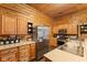 A cozy kitchen features wood paneled walls, neutral countertops, stainless steel appliances, and wood cabinets at 4131 N County Road 500 E, Danville, IN 46122