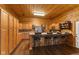 A rustic kitchen boasts wood paneling, warm wood cabinets, a stainless steel refrigerator, and a breakfast bar with stools at 4131 N County Road 500 E, Danville, IN 46122