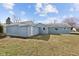 View of the home's light blue exterior, green grass, and spacious backyard at 453 Carol Dr, Greenwood, IN 46143