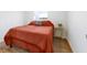 Cozy bedroom with hardwood floors, a comfortable bed with an orange comforter, and a small bedside table at 453 Carol Dr, Greenwood, IN 46143