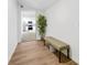 Bright hallway with hardwood floors, a decorative bench, and a view of a modern kitchen at 453 Carol Dr, Greenwood, IN 46143