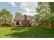 Backyard boasts a well-kept lawn, a wooden deck, and mature trees with privacy fence at 5208 Clear Lake Ct, Carmel, IN 46033