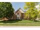 Charming two-story brick home with a well-manicured lawn and mature trees at 5208 Clear Lake Ct, Carmel, IN 46033