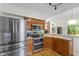Modern kitchen boasts stainless steel appliances, granite countertops, wooden cabinets and open view of the living room at 5208 Clear Lake Ct, Carmel, IN 46033