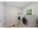 Functional laundry room with a window, tiled floors, washer, and dryer at 5208 Clear Lake Ct, Carmel, IN 46033