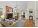 Bright living room boasts a brick fireplace, chandelier, and hardwood floors that flow into the dining area at 5208 Clear Lake Ct, Carmel, IN 46033