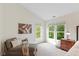 A sitting area in the primary bedroom with neutral colors and natural light coming through two windows at 5208 Clear Lake Ct, Carmel, IN 46033