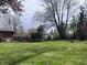 Expansive backyard featuring a trampoline, mature trees, and plenty of space for outdoor activities at 6632 Sargent Rd, Indianapolis, IN 46256