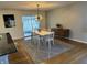 Bright dining area with wood floors, stylish lighting, and sliding doors to a sunroom overlooking a wooded area at 6632 Sargent Rd, Indianapolis, IN 46256