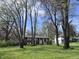 Traditional brick home surrounded by mature trees and a lush green lawn at 6632 Sargent Rd, Indianapolis, IN 46256