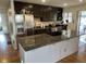 Modern kitchen features stainless steel appliances, dark cabinets, granite countertops, and center island with cooktop at 6632 Sargent Rd, Indianapolis, IN 46256