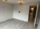 Open living room with light wood floors, bare walls, and doorway to another room at 6632 Sargent Rd, Indianapolis, IN 46256
