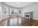 Bright living room featuring a brick fireplace, hardwood floors, and large windows at 806 S 17Th St, Elwood, IN 46036