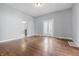 Open living room with hardwood floors, light walls, and glass doors leading to a kitchen at 806 S 17Th St, Elwood, IN 46036