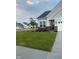 Beautifully landscaped front yard with lush lawn, brick accents, and gray siding on a sunny day at 9101 S Stone Trace S Blvd, Avon, IN 46123