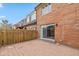 View of a brick townhouse from the fenced backyard with a patio at 1156 Canterbury N Sq, Indianapolis, IN 46260