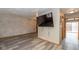 Comfortable living room with wood floors, a mounted TV, and access to additional spaces at 1156 Canterbury N Sq, Indianapolis, IN 46260