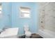 Bathroom featuring blue walls, white fixtures, and a tub shower with marble-look tile at 117 W 36Th St, Indianapolis, IN 46208