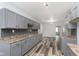 Bright kitchen featuring ample grey cabinetry, a mosaic backsplash, and new wood-look flooring at 117 W 36Th St, Indianapolis, IN 46208