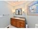 Bathroom with wood vanity, large mirror, and neutral blue walls at 11710 E 75Th St, Indianapolis, IN 46236