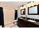 Brightly lit bathroom with double sinks, granite counters, two mirrors, and a subway tile shower at 11710 E 75Th St, Indianapolis, IN 46236