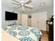 Bright bedroom with a ceiling fan, neutral walls, a pair of double doors, and warm-toned laminate floors at 11710 E 75Th St, Indianapolis, IN 46236