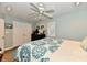 Bright bedroom with a ceiling fan, neutral walls, a pair of double doors, and warm-toned laminate floors at 11710 E 75Th St, Indianapolis, IN 46236
