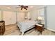 Bright bedroom with a ceiling fan, neutral walls, a pair of double doors, and warm-toned laminate floors at 11710 E 75Th St, Indianapolis, IN 46236