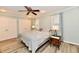 Bright bedroom with a ceiling fan, neutral walls, a pair of double doors, and warm-toned laminate floors at 11710 E 75Th St, Indianapolis, IN 46236