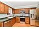 Well-lit kitchen featuring stainless steel appliances and wooden cabinetry at 11710 E 75Th St, Indianapolis, IN 46236