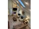 Vaulted living room with a stone fireplace, ceiling fan, skylight, and modern furnishings at 11710 E 75Th St, Indianapolis, IN 46236