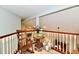 Cozy upstairs landing with a rocking chair, wooden railing, and soft lighting at 11710 E 75Th St, Indianapolis, IN 46236