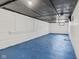 A large unfinished basement with blue painted floor and white-washed walls at 3950 W Michigan St, Indianapolis, IN 46222