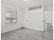 A sunlit bedroom featuring light grey laminate flooring and a bright window at 3950 W Michigan St, Indianapolis, IN 46222