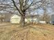 Modest single story home featuring an attached garage and a yellow entry door at 5430 Milhouse Rd, Indianapolis, IN 46221