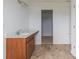 Bathroom with brown vanity, white sink, tile floor, closet, and modern lighting at 567 Hidden Hills Dr, Pittsboro, IN 46167