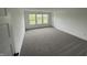 Bright bedroom featuring plush carpet, neutral walls, and three double hung windows at 567 Hidden Hills Dr, Pittsboro, IN 46167