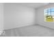 Bedroom featuring soft gray carpeting, crisp white walls, and a window that lets in ample natural light at 567 Hidden Hills Dr, Pittsboro, IN 46167