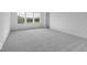 A spacious bedroom with grey carpet, white walls, and three bright windows with backyard views at 567 Hidden Hills Dr, Pittsboro, IN 46167