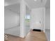 Bright entryway featuring wood floors, carpeted living room, white walls, and a welcoming front door at 567 Hidden Hills Dr, Pittsboro, IN 46167