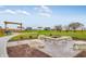 Community firepit area with stone seating and a pergola, perfect for outdoor gatherings at 567 Hidden Hills Dr, Pittsboro, IN 46167