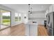 A bright kitchen with stainless steel appliances and an island with backyard views through a sliding glass door at 567 Hidden Hills Dr, Pittsboro, IN 46167