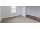 Open living room with plush carpeting and a window offering natural light, next to the entrance at 567 Hidden Hills Dr, Pittsboro, IN 46167