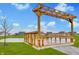 View of the wooden pergola structure overlooking the pond at 567 Hidden Hills Dr, Pittsboro, IN 46167