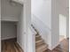 Staircase featuring carpeted steps, white banister and landing with wood floors at 567 Hidden Hills Dr, Pittsboro, IN 46167