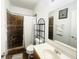 Bathroom featuring a vanity, toilet, large mirror, and shower with brown tile surround at 6405 Oyster Key Ln, Plainfield, IN 46168