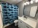 Well-lit bathroom features a shark-themed shower curtain and modern vanity with black hardware at 8048 Garden Ridge Rd, Indianapolis, IN 46237