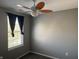 A cozy bedroom featuring a window with curtains and a fan at 8048 Garden Ridge Rd, Indianapolis, IN 46237