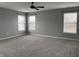This bedroom features neutral-colored walls, a ceiling fan, and large windows at 8048 Garden Ridge Rd, Indianapolis, IN 46237